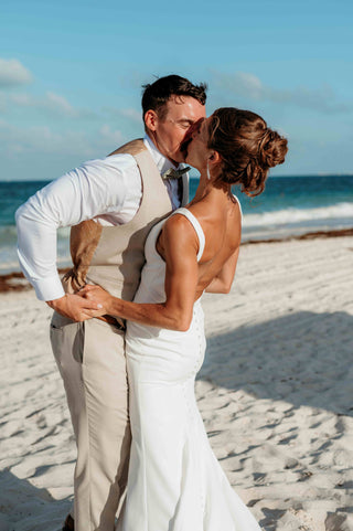 Photograph of bride and groom embracing at the beach of their beach wedding ceremony