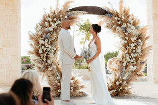 wedding couple at courtyard with a floral gazebo at sunset