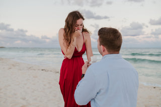 Man proposing to his girlfriend who looks surprised on the beach during a cancun proposal at sunset