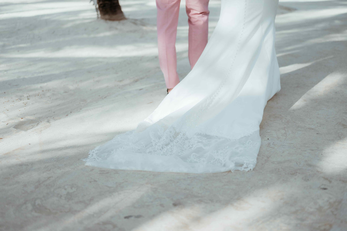 Photograph of bride and groom walking on the sand at their beach wedding