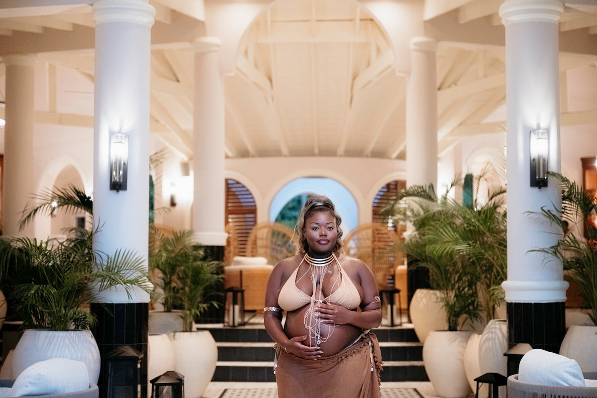 Photograph of a soon-to-be mother holding her baby bump in the lobby of a luxury St. Lucia hotel