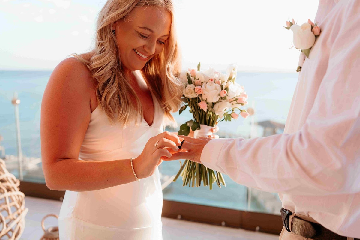 Photograph of a bride placing the ring on her soon-to-be husband's finger, captured by a DreamArt photographer