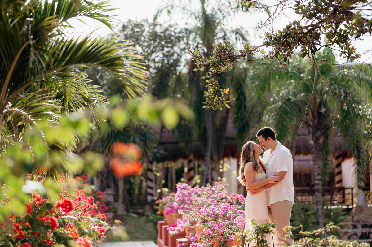 Photograph of couple embracing in their Mexican hotel among the flowers, captured by a DreamArt photographer