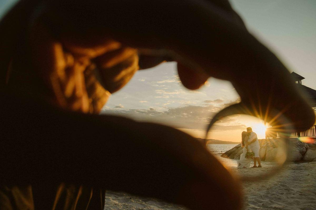Photograph of a couple kissing, photographed through the perspective of a wedding ring