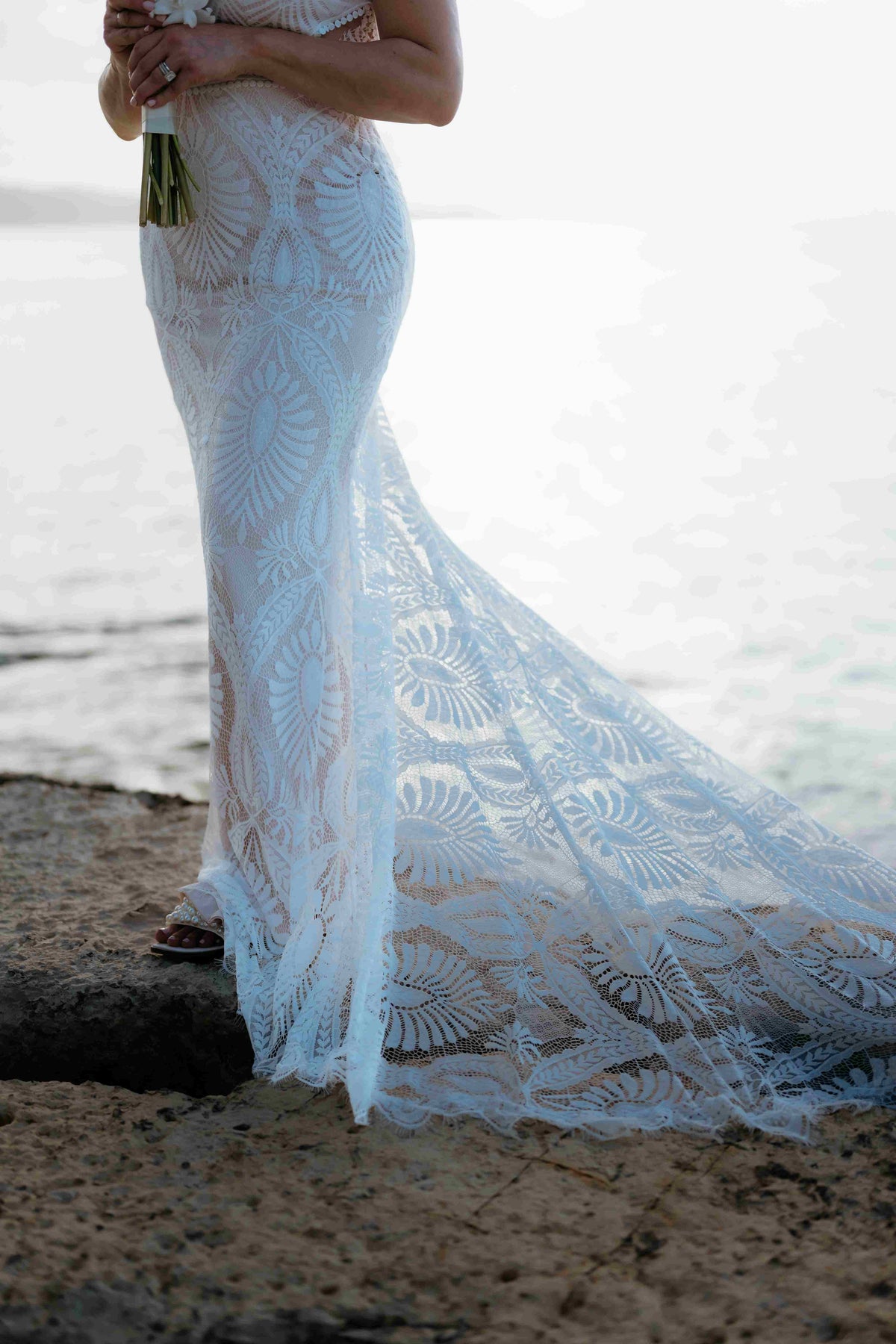 Photograph of the bottom of the bride's dress on the beach, captured by a DreamArt photographer