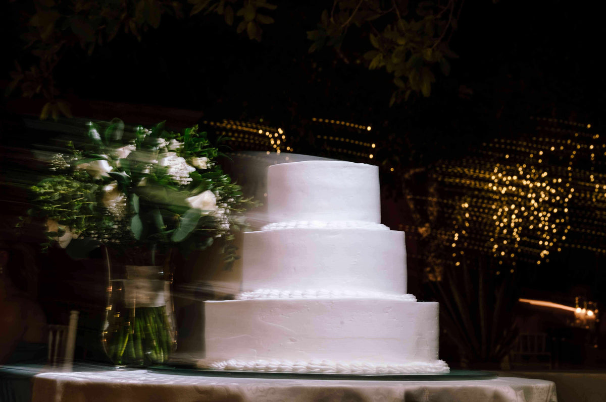 Blurry shot of a classic white wedding cake, captured by a DreamArt photographer