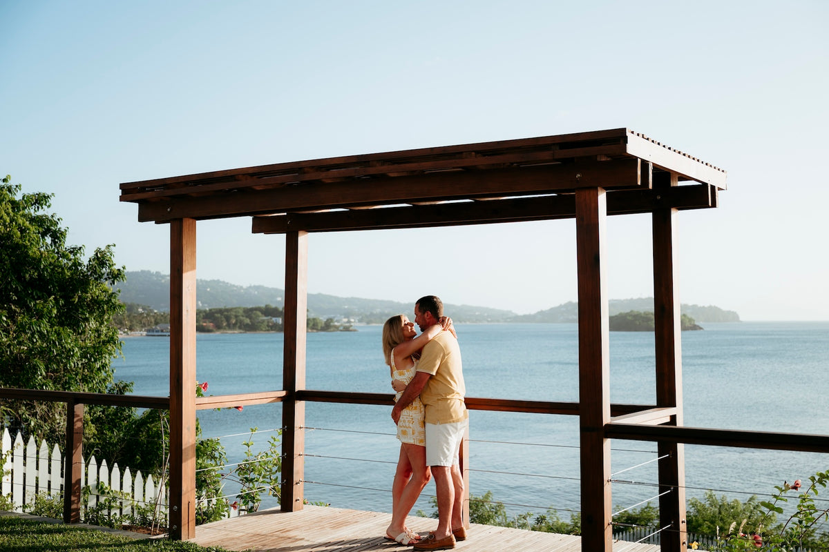 Photograph of a couple embracing in front of the ocean at Secrets St. Lucia luxury hotel