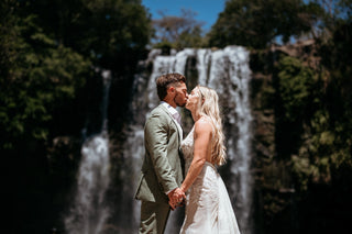Photograph of a bride and groom kissing in front of a Costa Rican waterfall, captured by a DreamArt Photographer for a Trash Photoshoot
