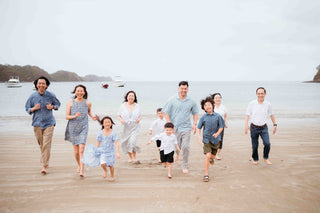 Photograph of a family running towards the camera on the beach, captured by a DreamArt photographer