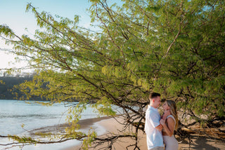 Photograph of couple embracing under a tree on the beach, captured by a DreamArt photographer 