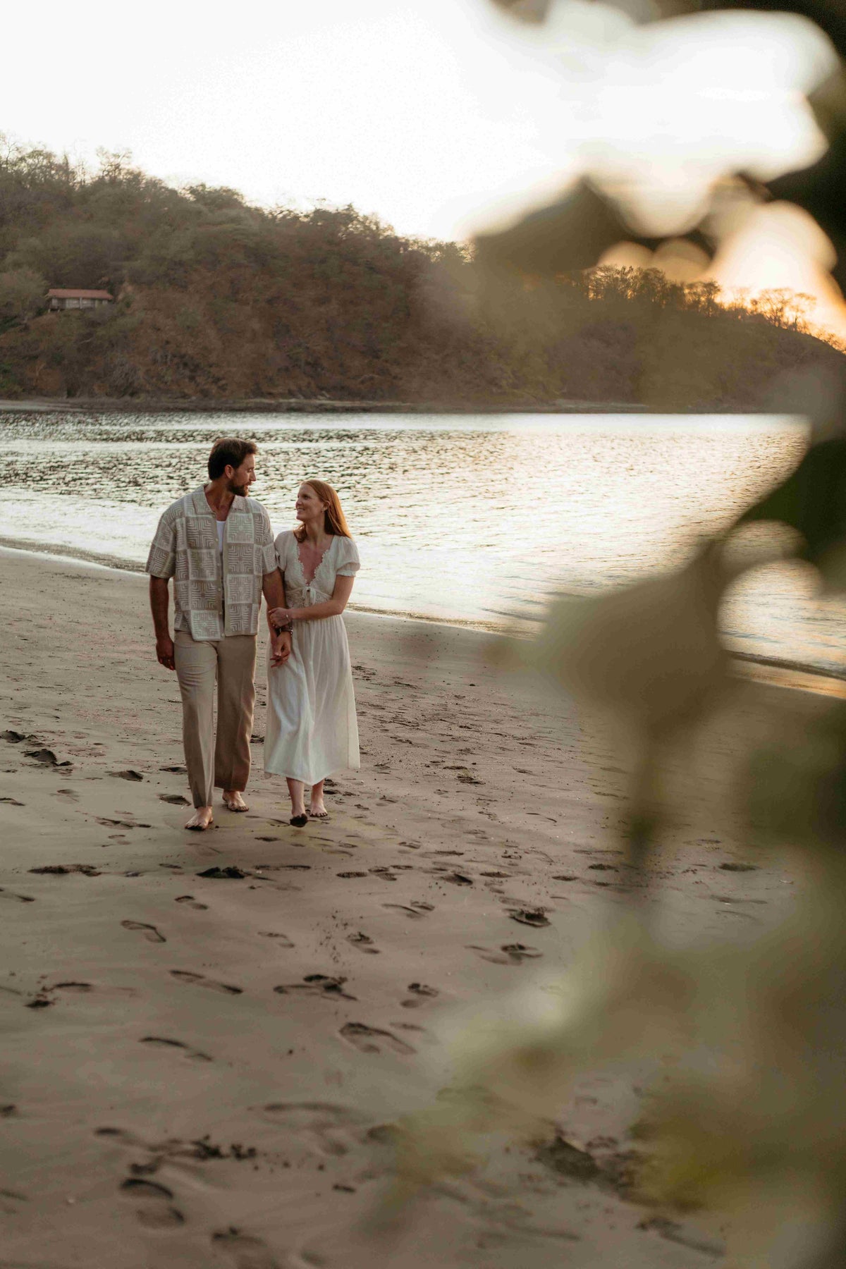 Photograph of a couple walking on the beach holding hands, captured by a DreamArt photographer