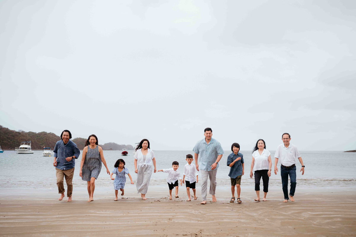 Photograph of a big family running towards the camera on the beach, captured by a DreamArt photographer