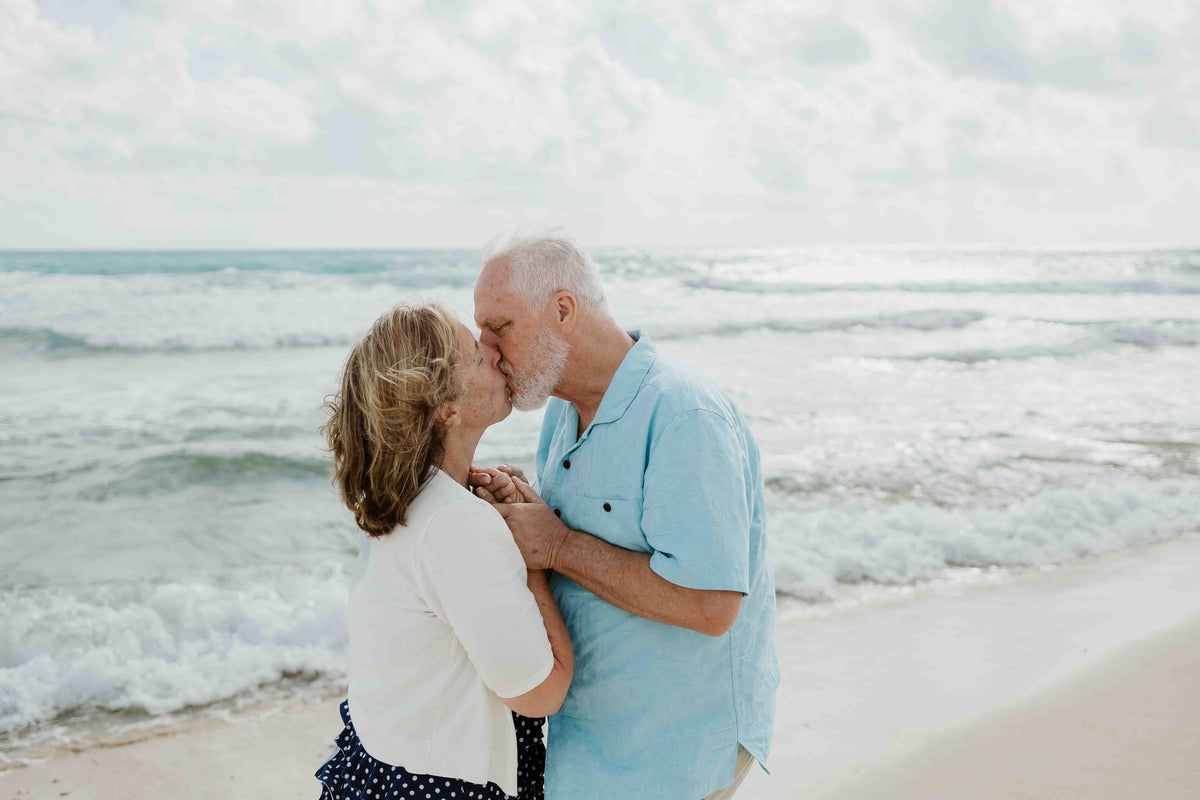Photograph of a couple kissing on the beach, captured by a DreamArt photographer