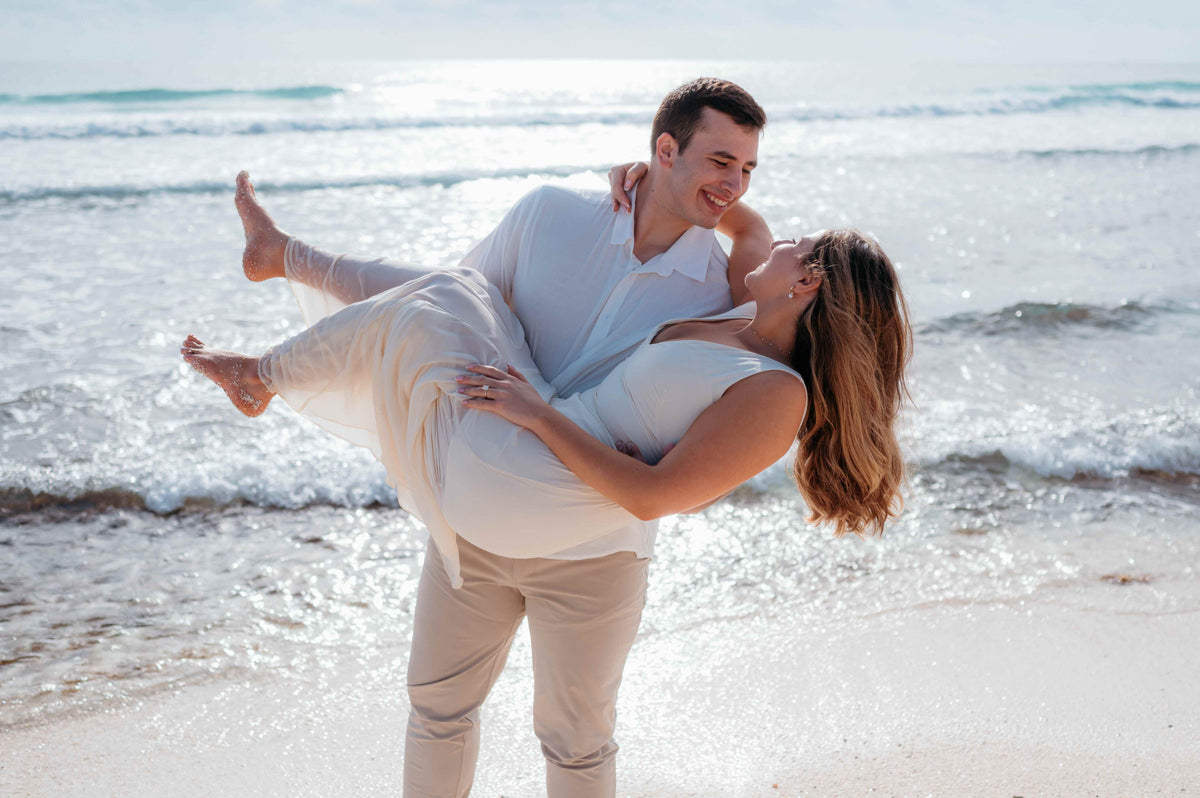 Photograph of an engaged couple on the beach taken by a DreamArt photographer