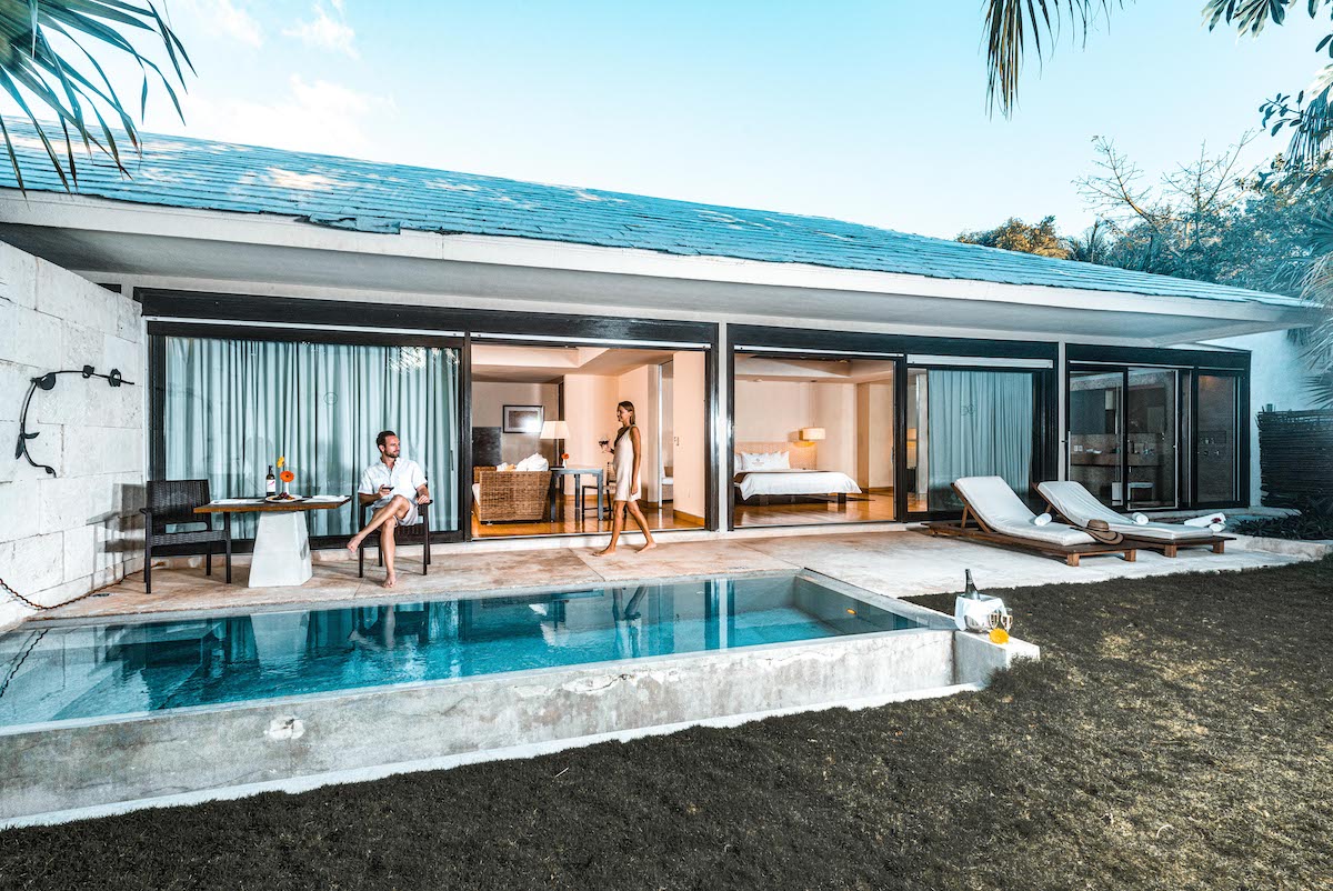 Couple relax by a private plunge pool outside a modern swim-up suite at Blue Diamond
