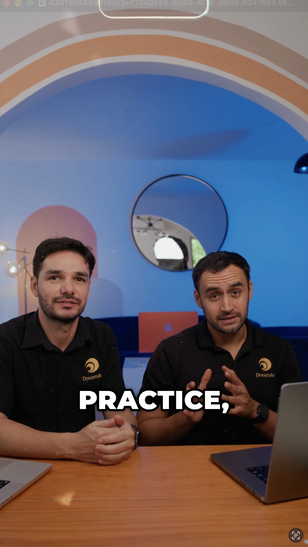 Two DreamArt instructors in black polos talk at a desk on the photography bootcamp film cover