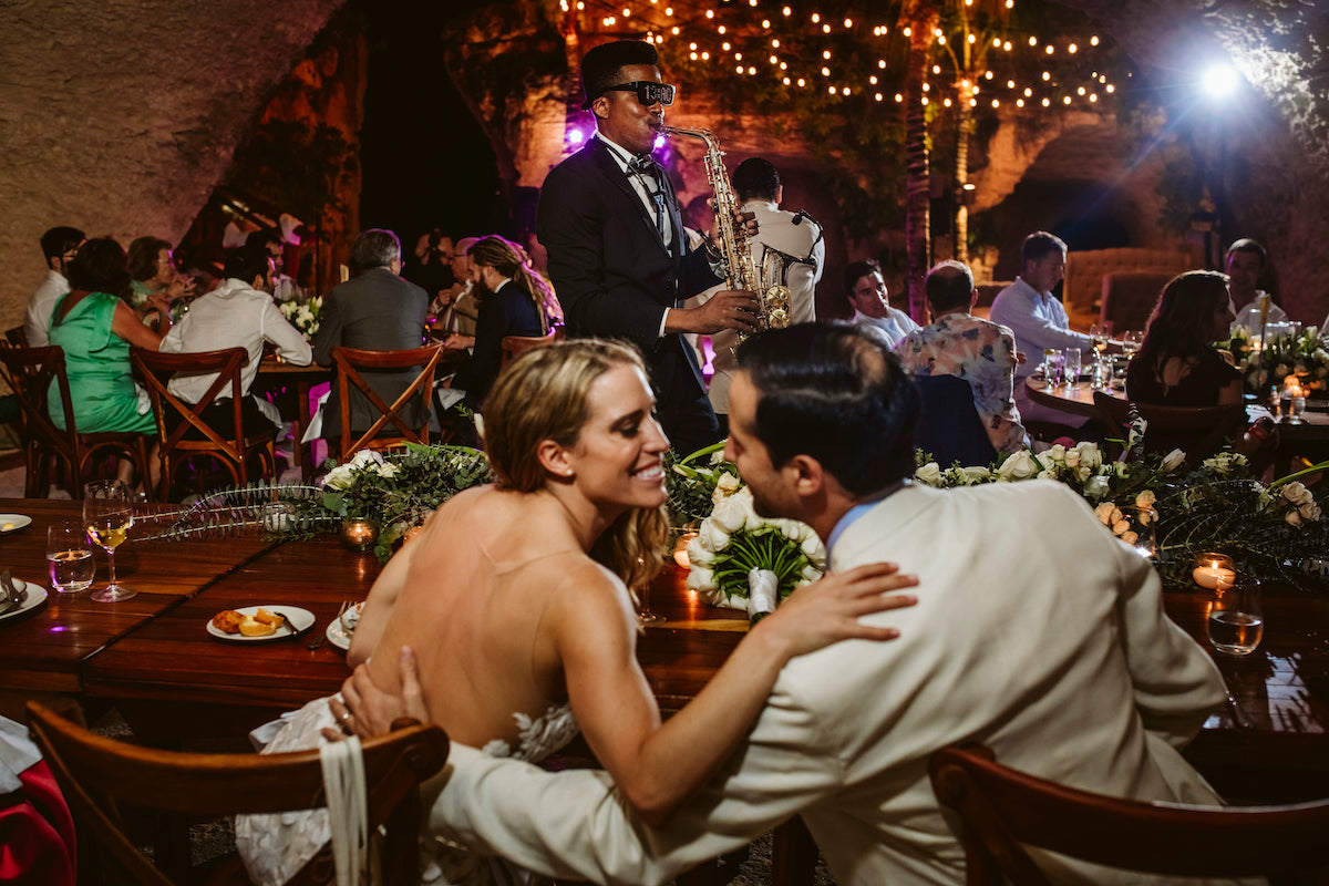 Bride and groom smiling at each other during wedding reception dinner