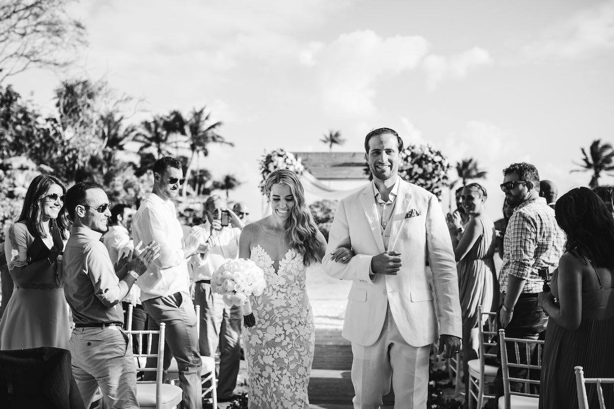 Just married couple walk down the aisle smiling