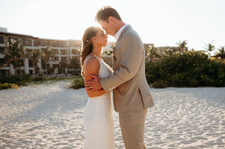 Couple by the beach in a beautiful sunset with the resort at the back 