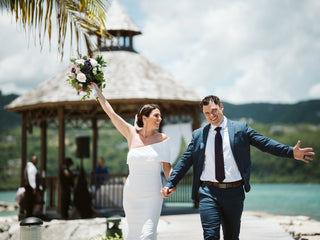 happy wedding couple with ocean and mountains at the back sunny island vibes. 