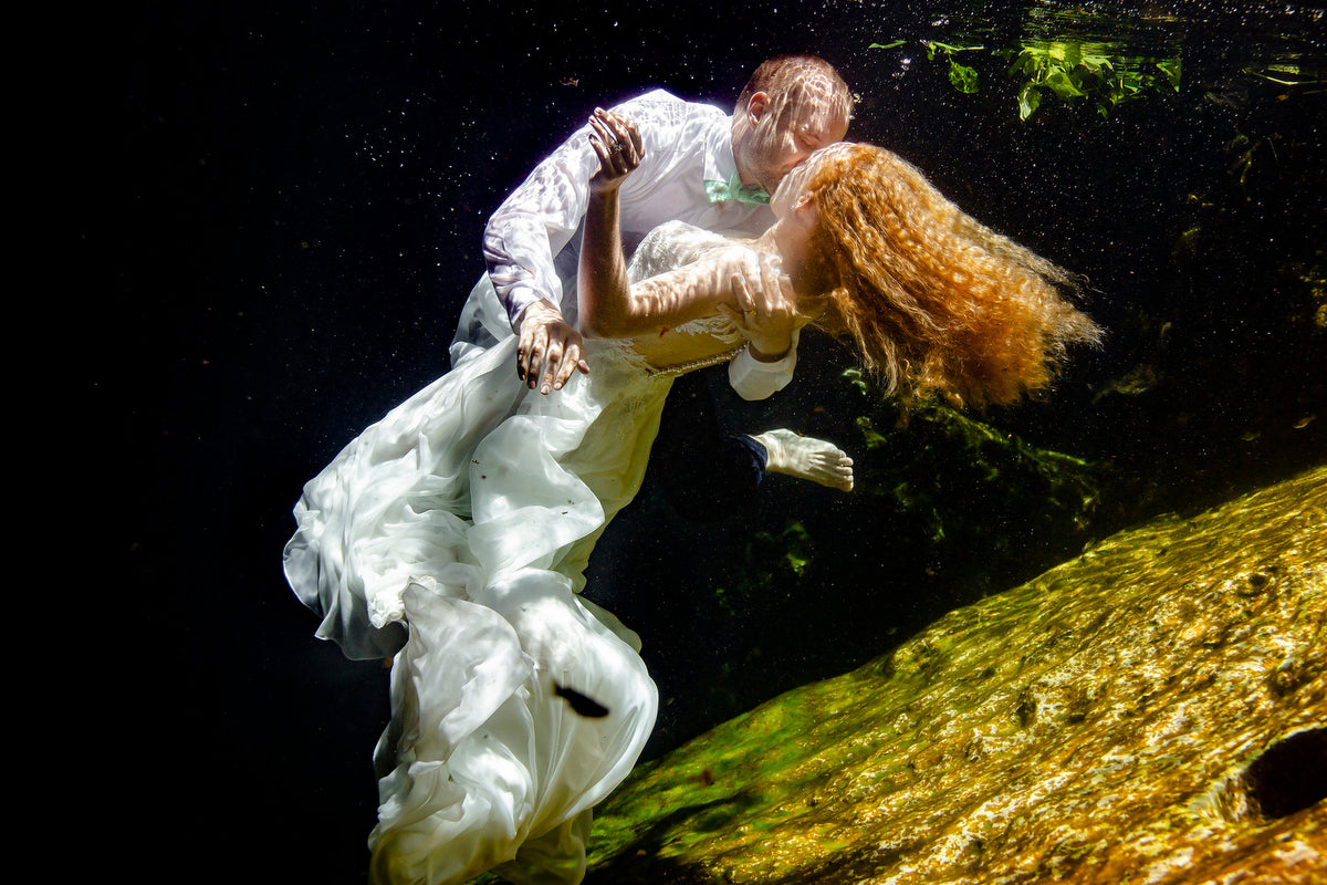 Couple during underwater trash the dress