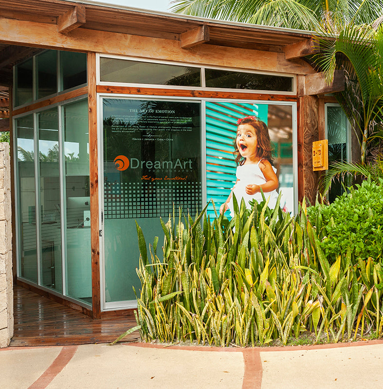 DreamArt Photography lounge with glass doors and a large portrait of a delighted girl at Vidanta Riviera Maya