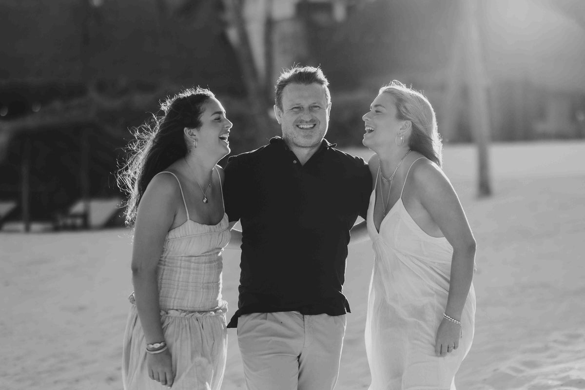 Photograph of a father and his two girls laughing together