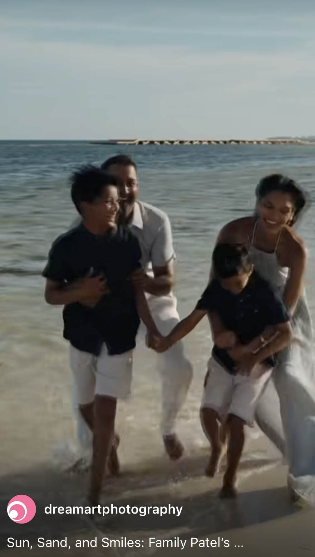Family film reel cover of parents and two boys laughing as they run out of the sea