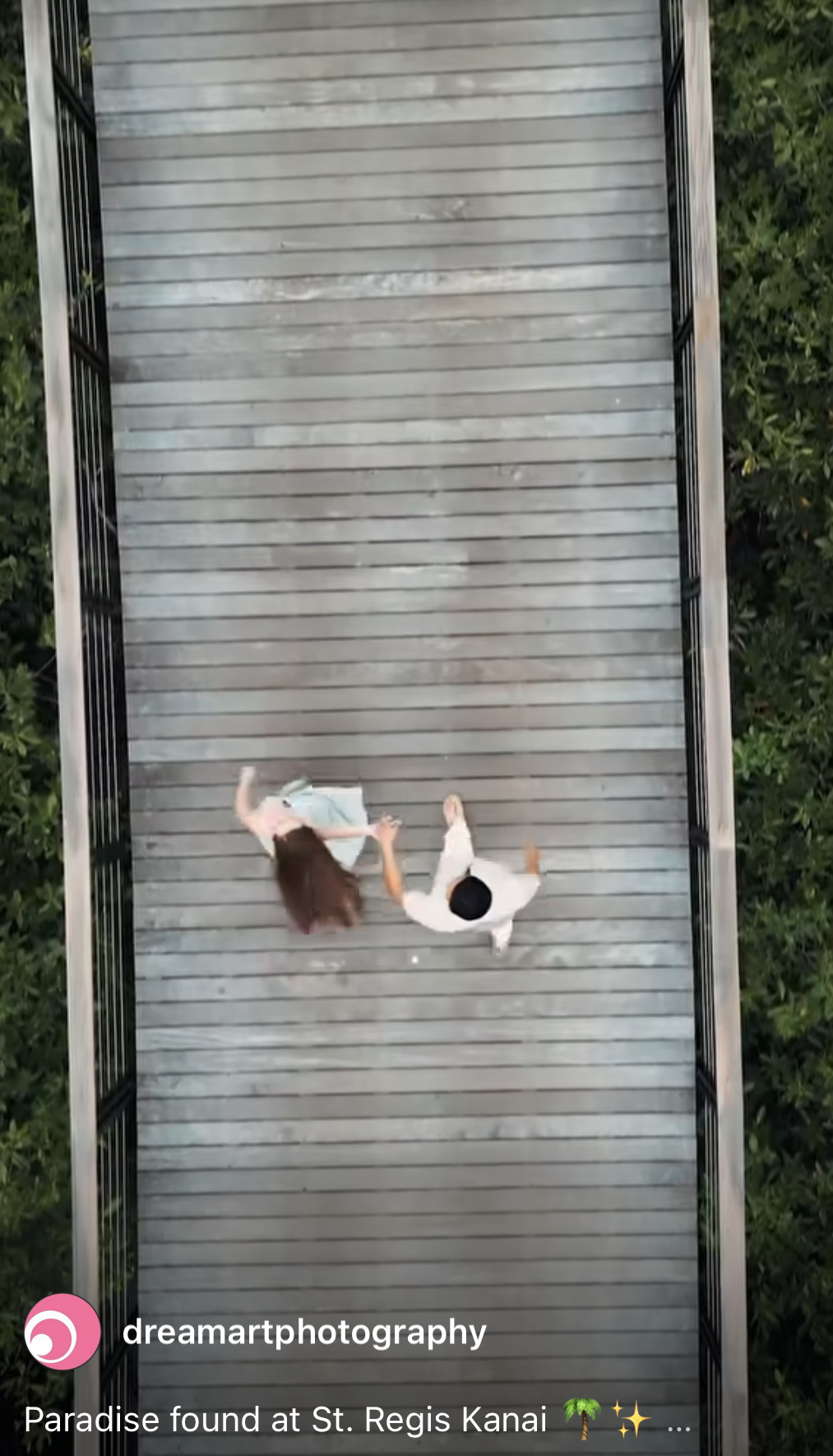Short film reel cover showing a drone view of a couple walking across a wooden jungle bridge
