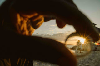 Photograph of bride and groom kissing, framed by a ring 