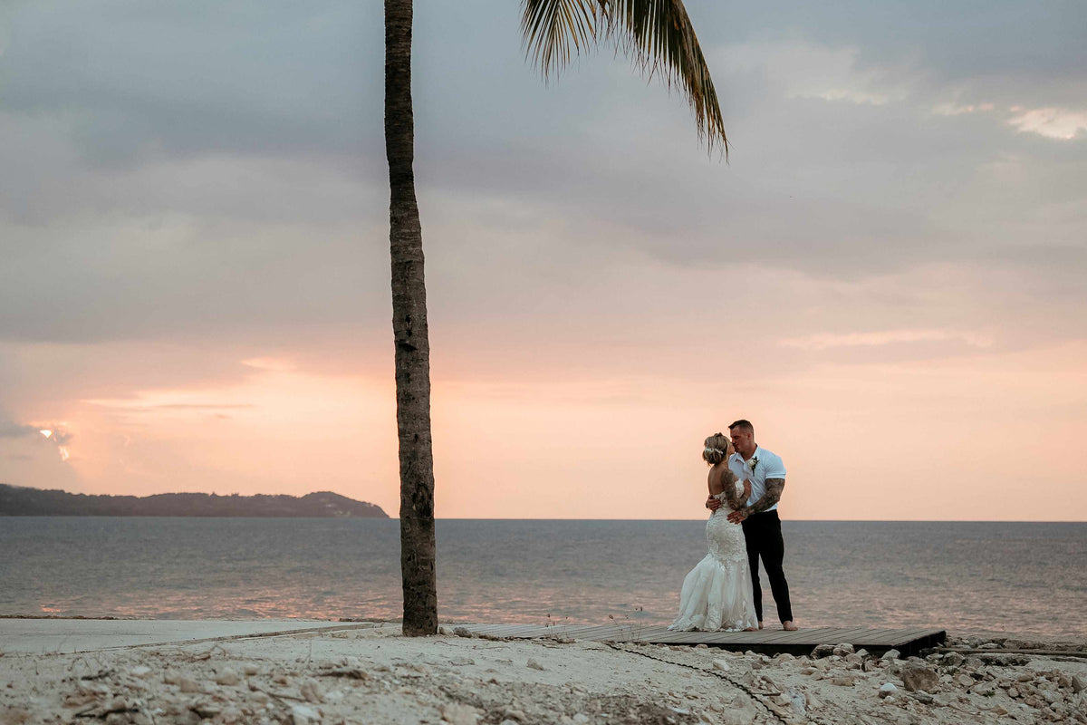 Photograph of bride and groom embracing on a Jamaican beach