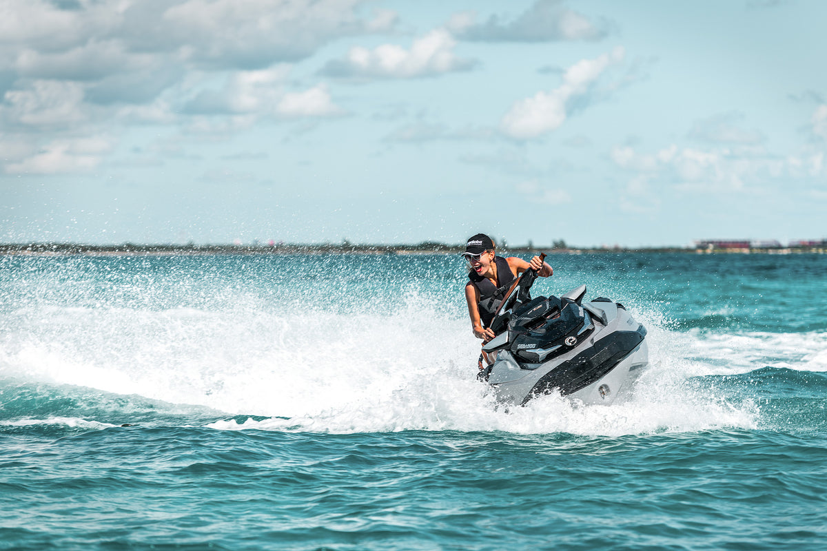 Man rides a jet ski across turquoise water with spray flying for resort marketing content