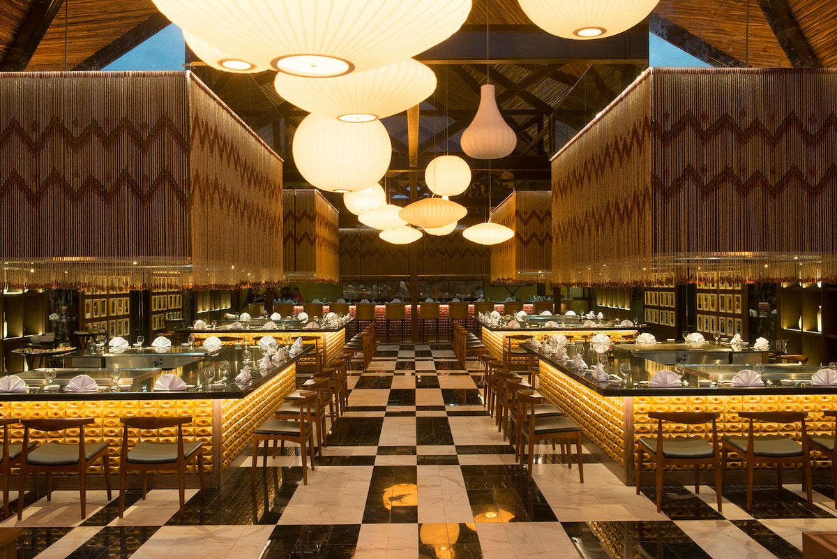 Restaurant interior with paper lantern pendants, beaded curtains and a checkered marble floor at Ocean Riviera Paradise