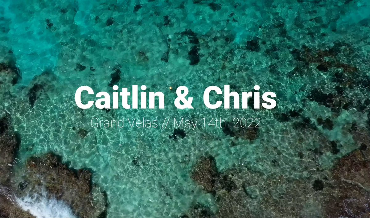 Drone view of turquoise reef water with the title card of a Grand Velas wedding film