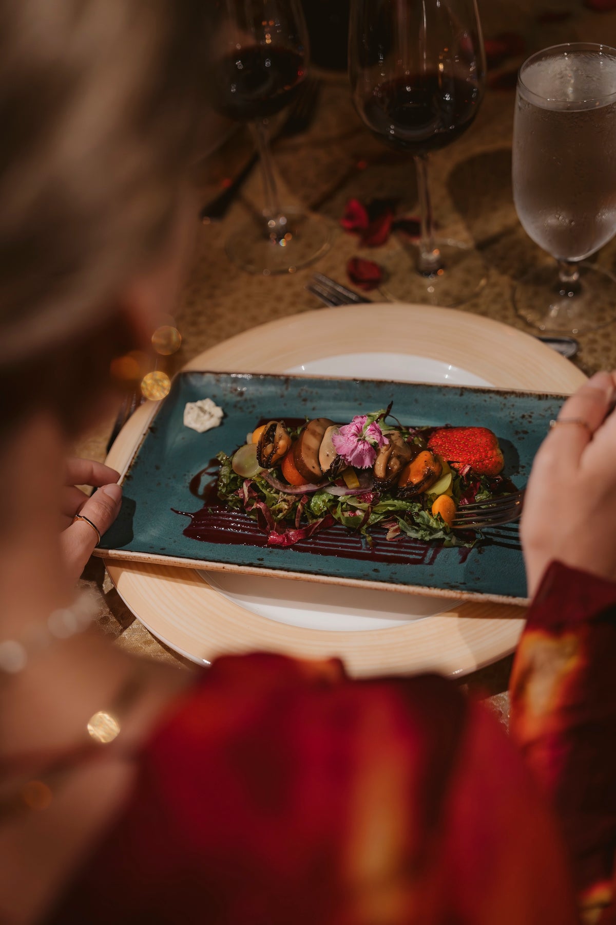 Gourmet plated dish with edible flowers served at a candlelit dinner at Secrets Papagayo Costa Rica