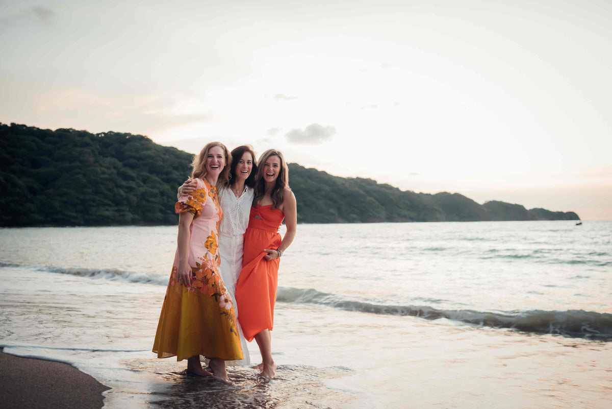 Three women posing on the beach for a DreamArt photographer, used for blog about Summer Trends 2025