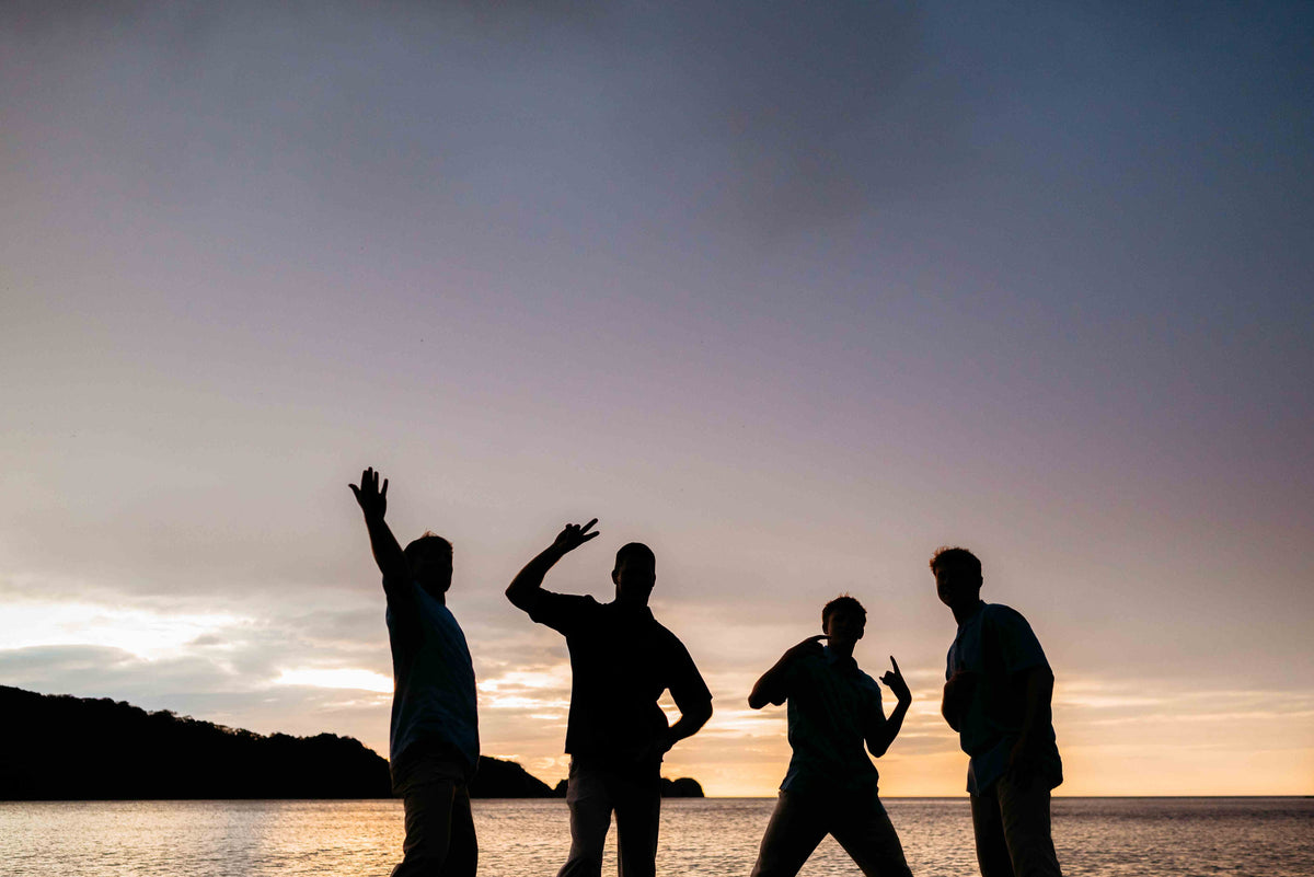 Image of a family dancing on the beach at sunset, posing for a DreamArt photographer, used for blog about Summer Trends 2025