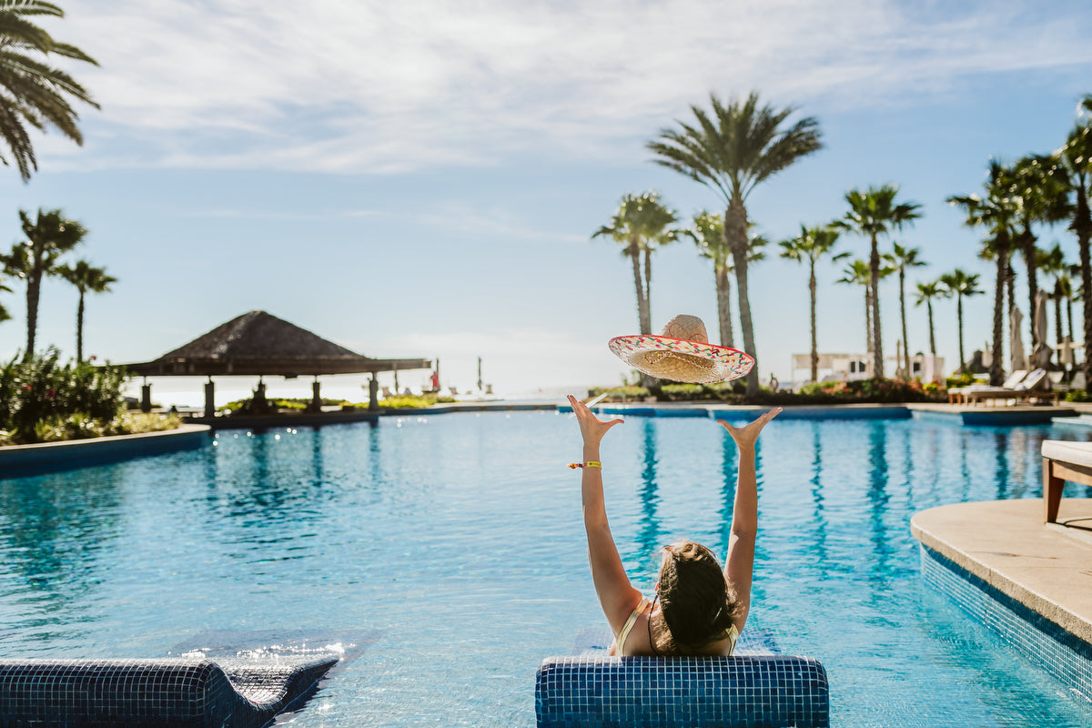 Bride with the hat in the pool at Vidanta Los Cabos