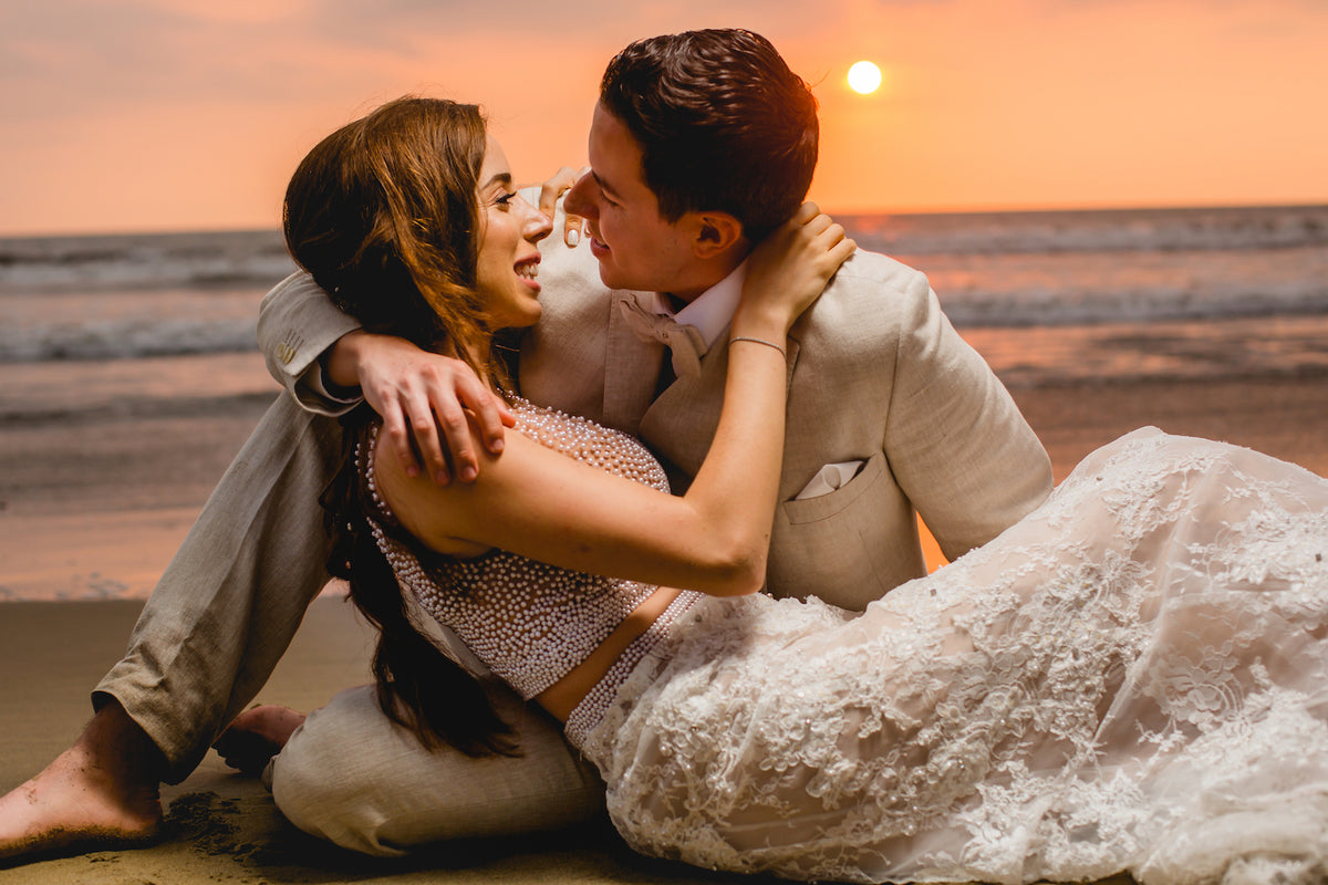 Bride and groom embrace on the sand at sunset during a trash the dress photoshoot