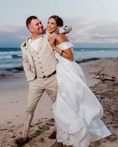 Bride and groom laughing together on the beach at Valentin Imperial Riviera Maya, Mexico