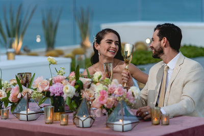 Bride and groom raise a toast at their reception table in Los Cabos