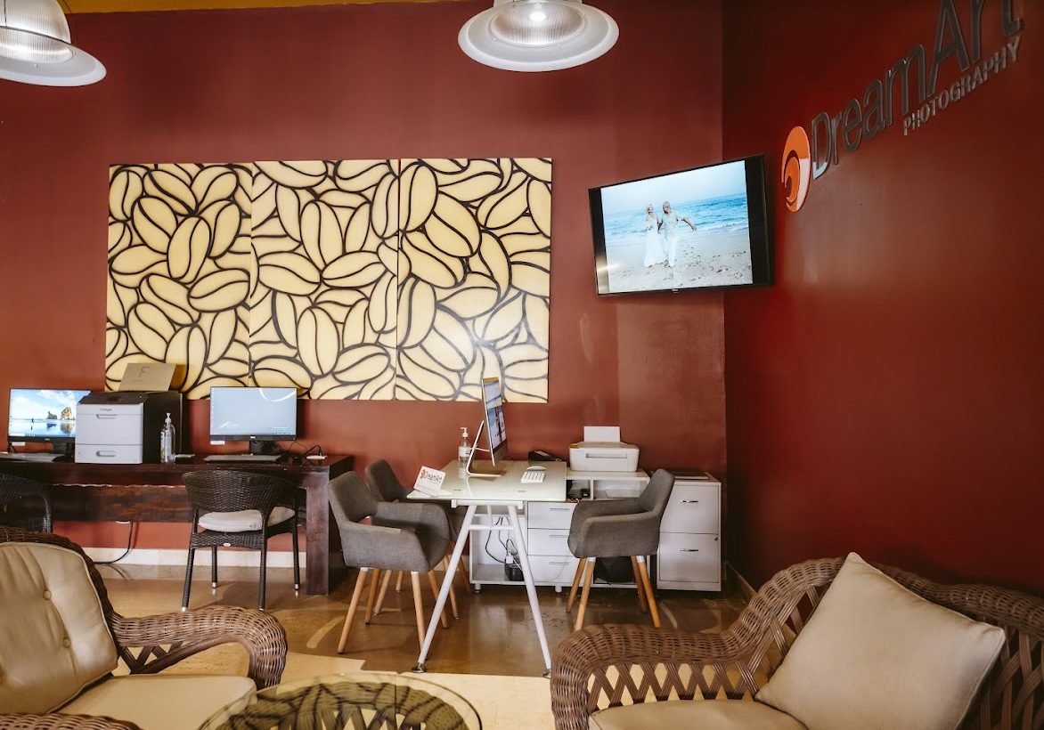 DreamArt Photography studio lounge with wicker chairs and editing desks at Grand Fiesta Americana Los Cabos