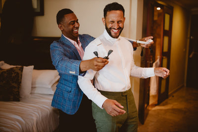 Groom laughing with his best man while getting ready