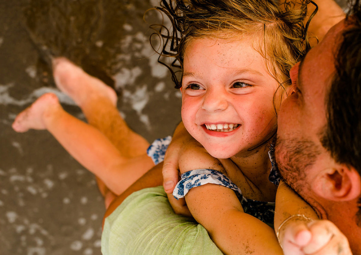 beautiful girl with her father in a photo shoot on the beach