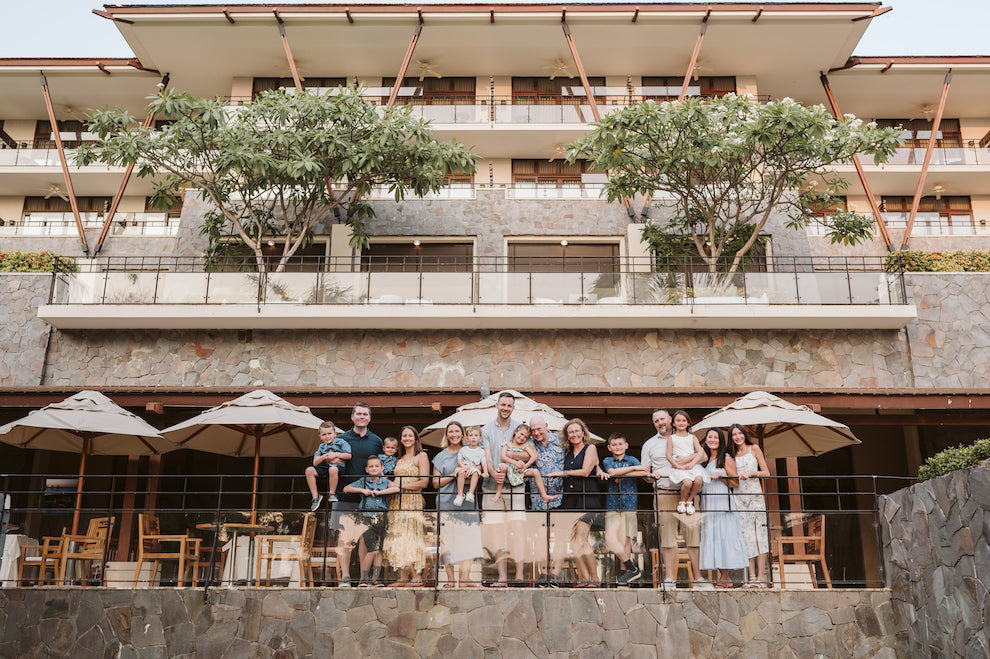 Large multigenerational family poses on a resort terrace under umbrellas in Guanacaste, Costa Rica