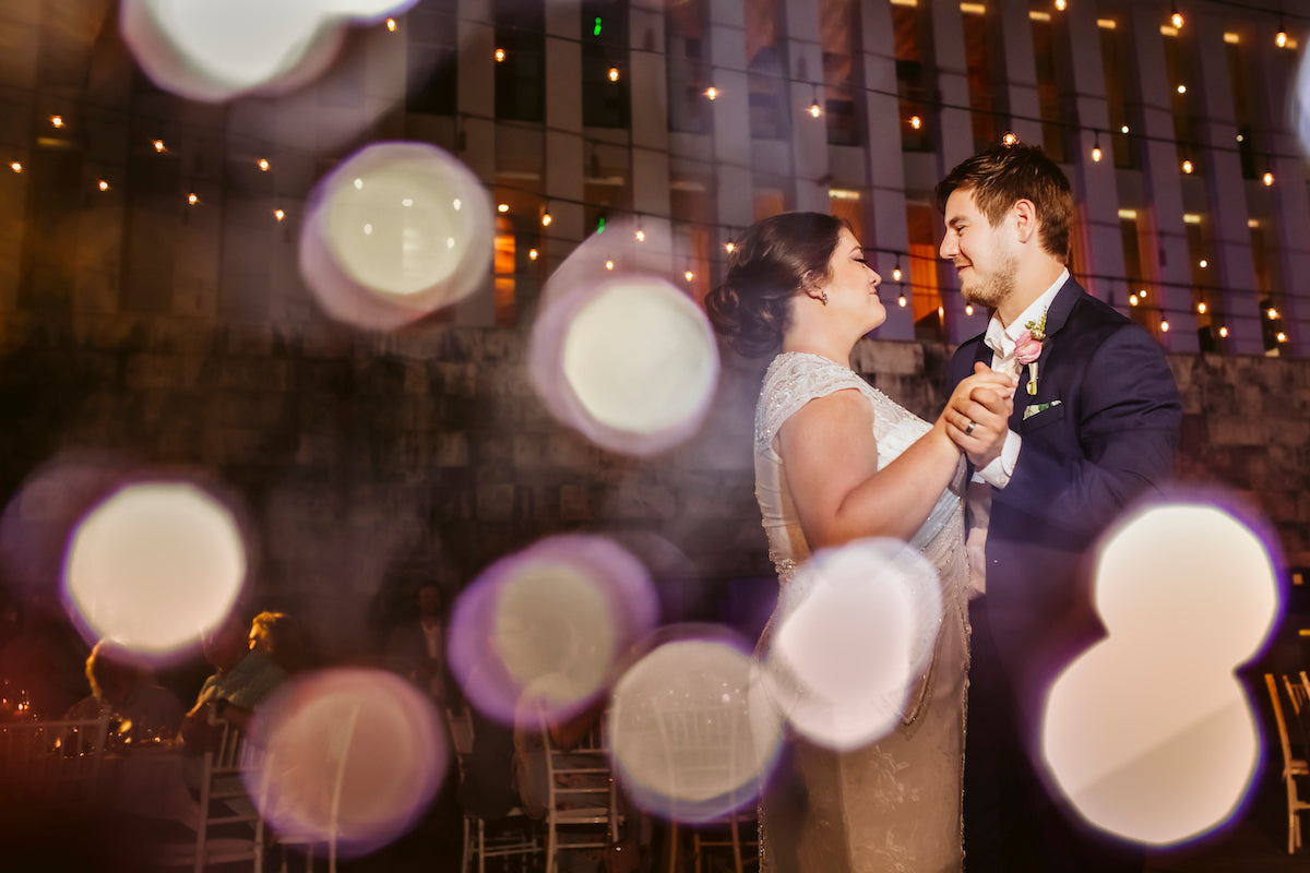 Bride and groom share a first dance under string lights and glowing bokeh at Grand Hyatt Playa del Carmen