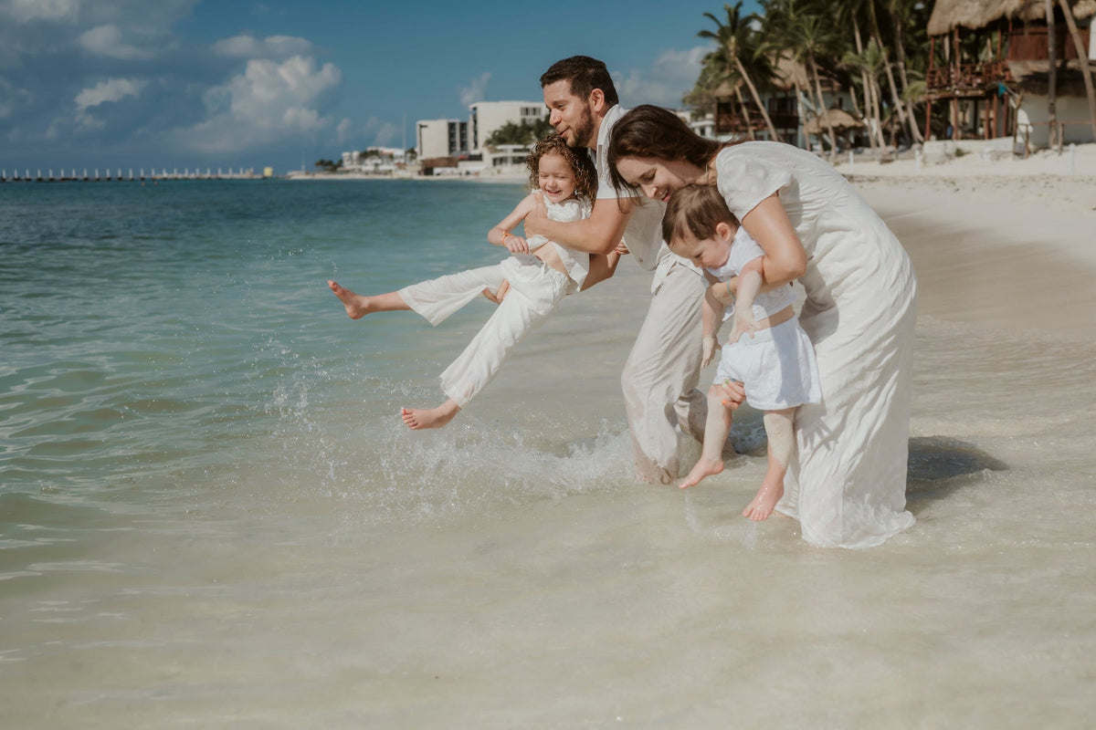Family playing in ocean during by photographer in beach photoshoot at mahekal beach resort