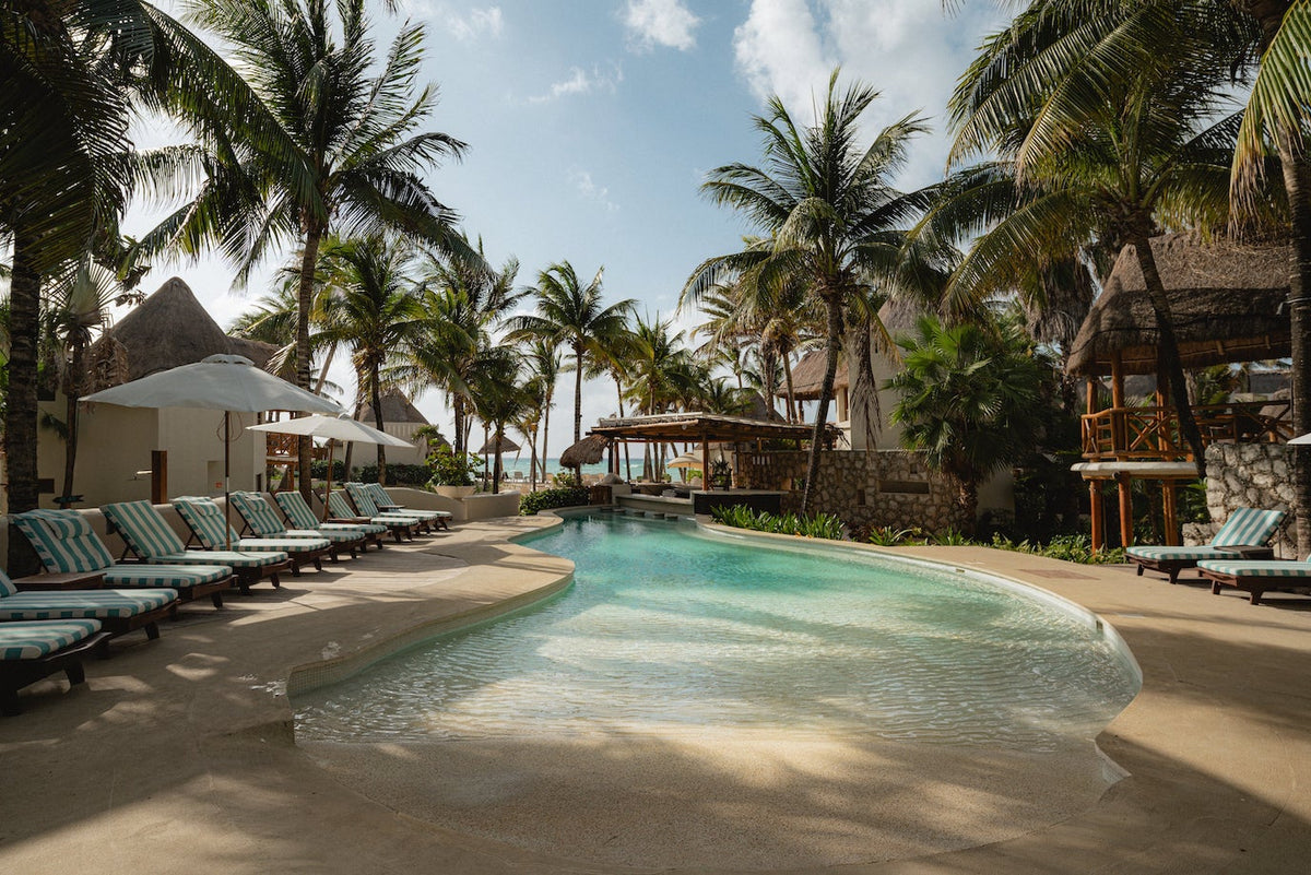 Pool photoshoot by photographer with loungers in tropical setting at Mahekal Beach Resort