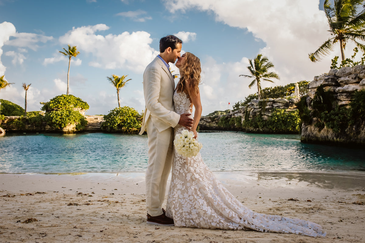 Bride and groom kissing with lagoon background