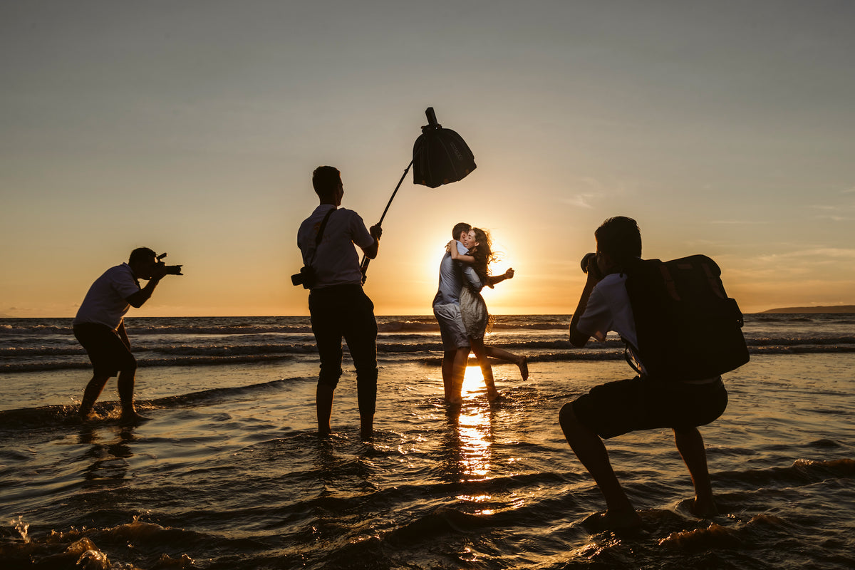 DreamArt photographers shoot a couple kissing in the surf at sunset at Secrets Papagayo Costa Rica